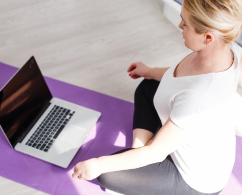 Picture of woman getting ready to view an on-demand session from Rivercity Pilates on her computer