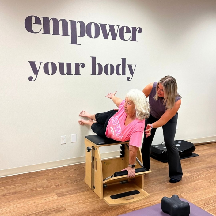 Carey sadler guiding a pilates client when doing an exercise.